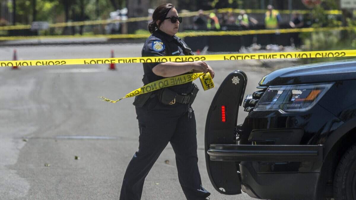 A Sacramento police officer returns to her car after putting up police tape on Grasslands Drive on Tuesday. A woman out for a noon jog was fatally struck by a hit-and-run driver near Barandas Park in the South Natomas area.