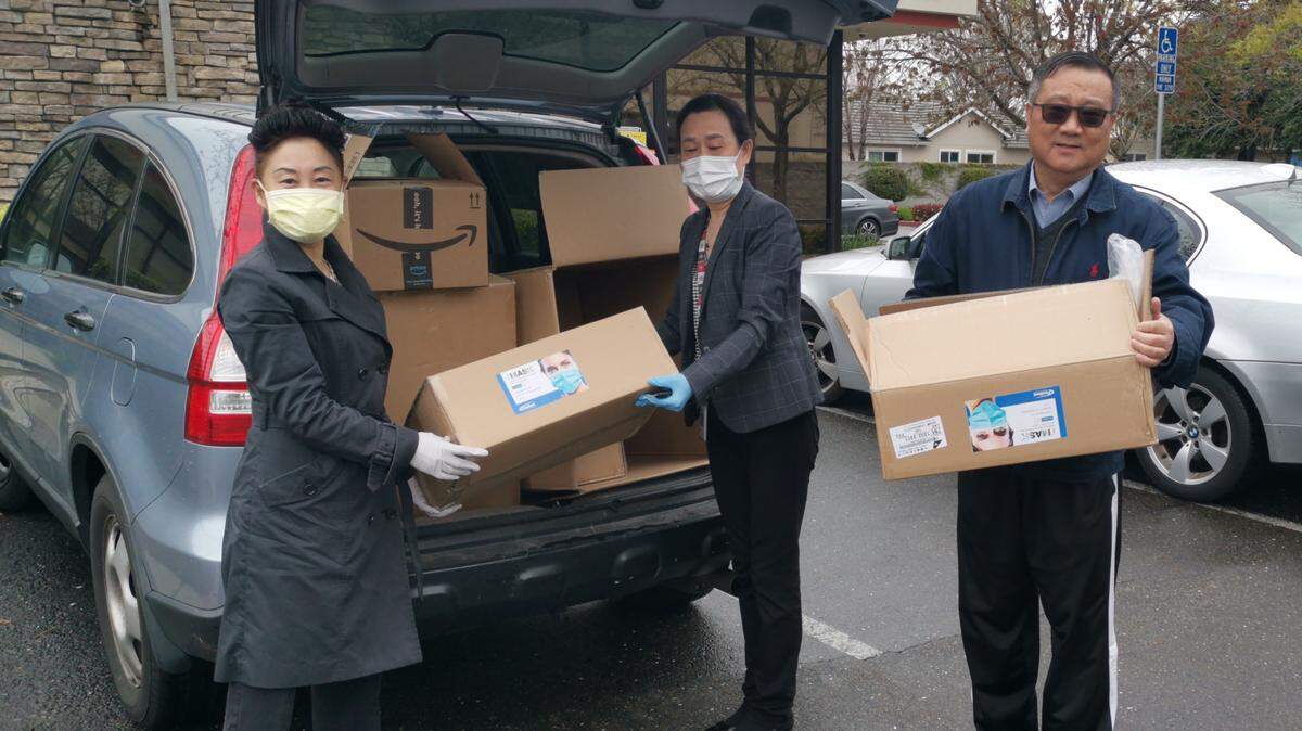 Volunteers of the Zhejiang University Alumni Association deliver masks bought with donations to Sacramento clinic Dawei Family Medicine on April 4.