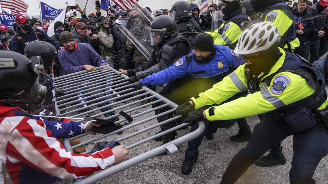 In this Jan. 6, 2021, file photo rioters try to break through a police barrier at the Capitol in Washington. A Georgia police officer (not pictured) is facing federal charges after he allegedly bragged and posted to social media about participating in the deadly U.S. Capitol siege.