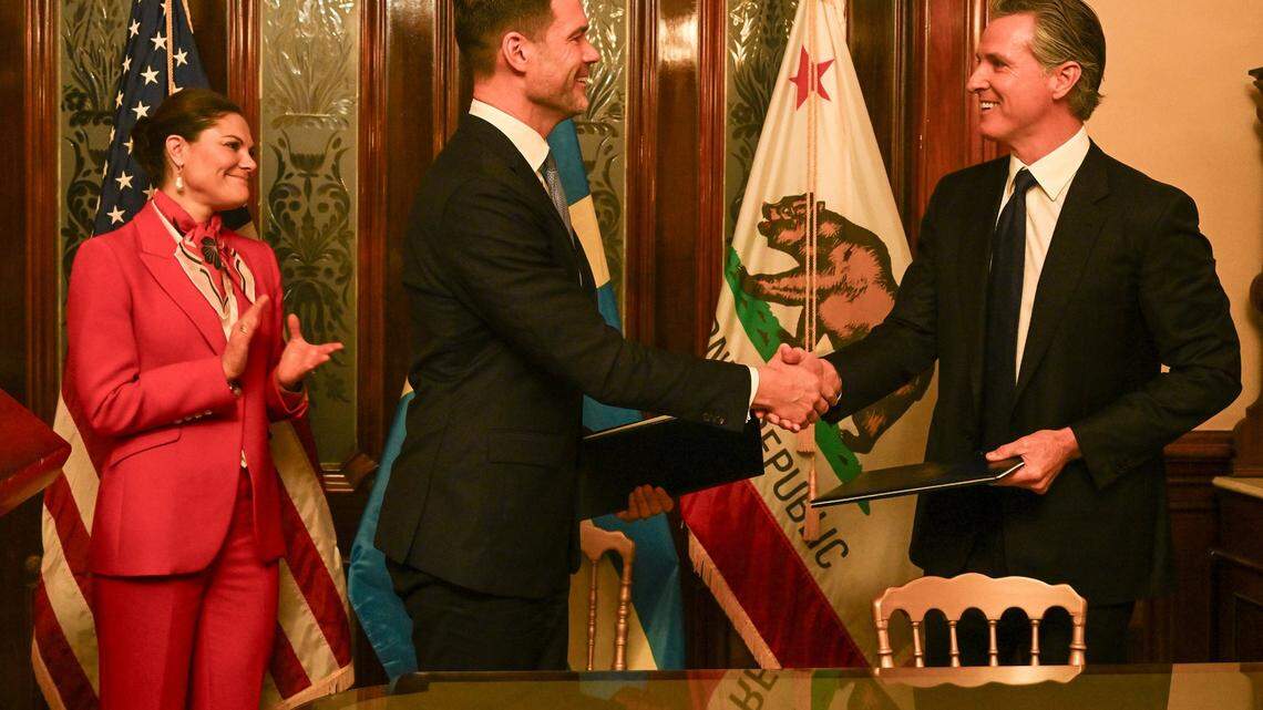 Gov. Gavin Newsom, left,  and Johan Forssell, center, Sweden’s minister for international development and foreign trade, shake hands in 2024 after signing a renewed climate partnership between California and Sweden.  Crown Princess Victoria of Sweden stands at left.