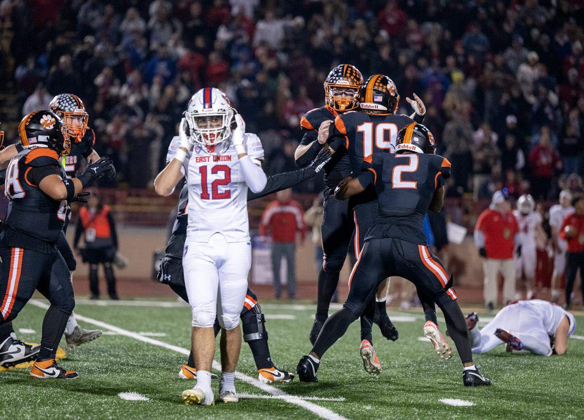 The Roseville Tigers' Austin Chang (19) is mobbed by his teammates after kicking the go ahead field goal in the final seconds in the second half of the CIF Sac-Joaquin Section football Division lV championship game against the East Union Lancers on Saturday, Nov. 29, 2025, at Hughes Stadium in Sacramento.