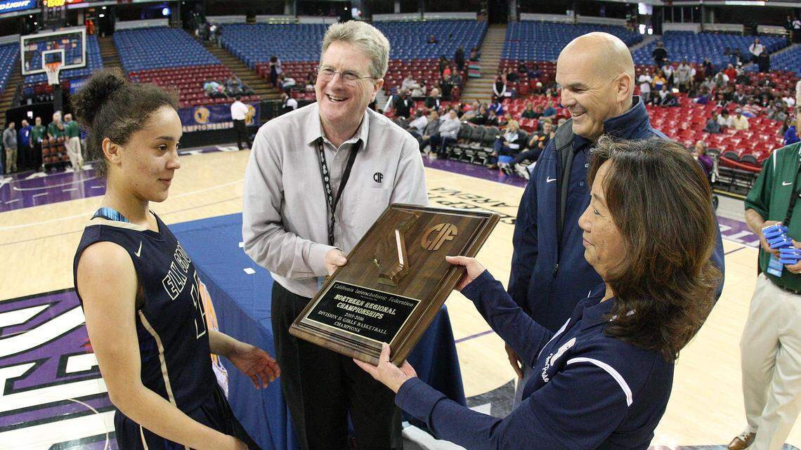 CIF executive director Roger Blake awards a trophy to the Elk Grove girls basketball team after the Thundering Herd won the Northern California Regional Division II title game at Sleep Train Arena in 2016.