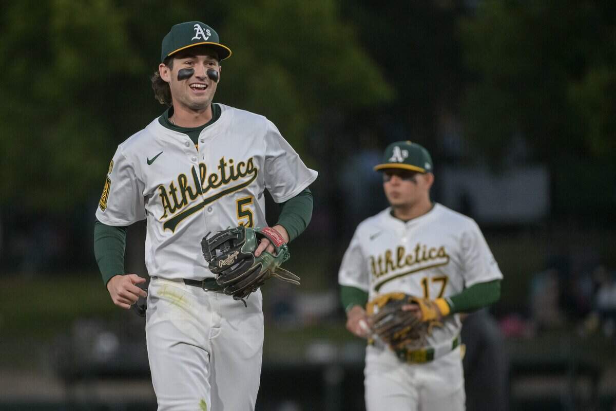 Apr 24, 2025; West Sacramento, California, USA; Athletics shortstop Jacob Wilson (5) and third baseman Luis Ur'as (17) return to the dugout after retiring the Texas Rangers during the third inning at Sutter Health Park. Mandatory Credit: Ed Szczepanski-Imagn Images