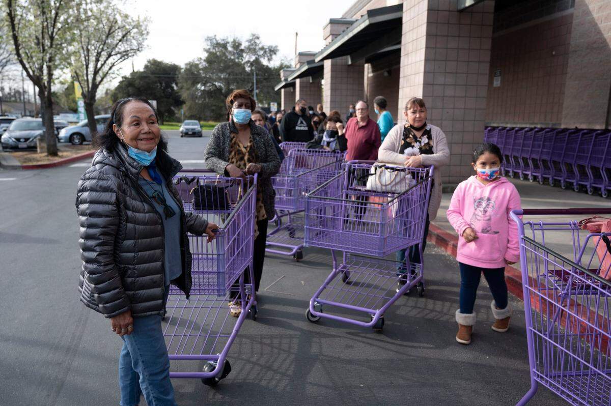 Veronica Pereyra, left, Lillian Tyson, Angelica Duran and her granddaughter Mariana Reyes, 6, wait in line Wednesday morning during the grand opening of the market.