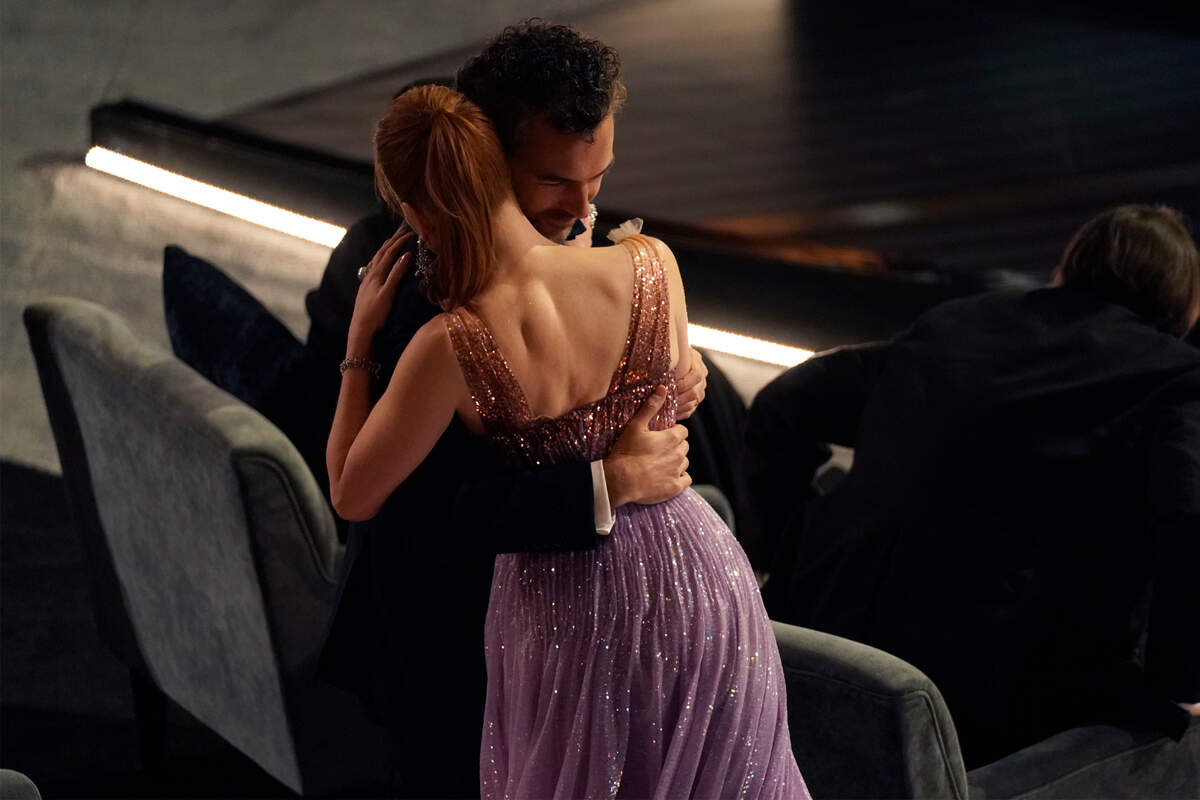 Gian Luca Passi de Preposulo, left, hugs Jessica Chastain as she is announced best performance by an actress in a leading role for “The Eyes of Tammy Faye” at the Oscars on Sunday, March 27, 2022, at the Dolby Theatre in Los Angeles. (AP Photo/Chris Pizzello)