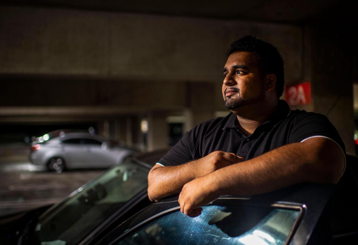 Student Alvin Prasad, 31, poses for a portrait outside of his car in a parking lot at Sacramento State on Wednesday, Sept. 26, 2019. Prasad, who studied mechanical engineering, would commute from Modesto and sleep in his car or other places on campus during busy times of the school year to avoid driving home.