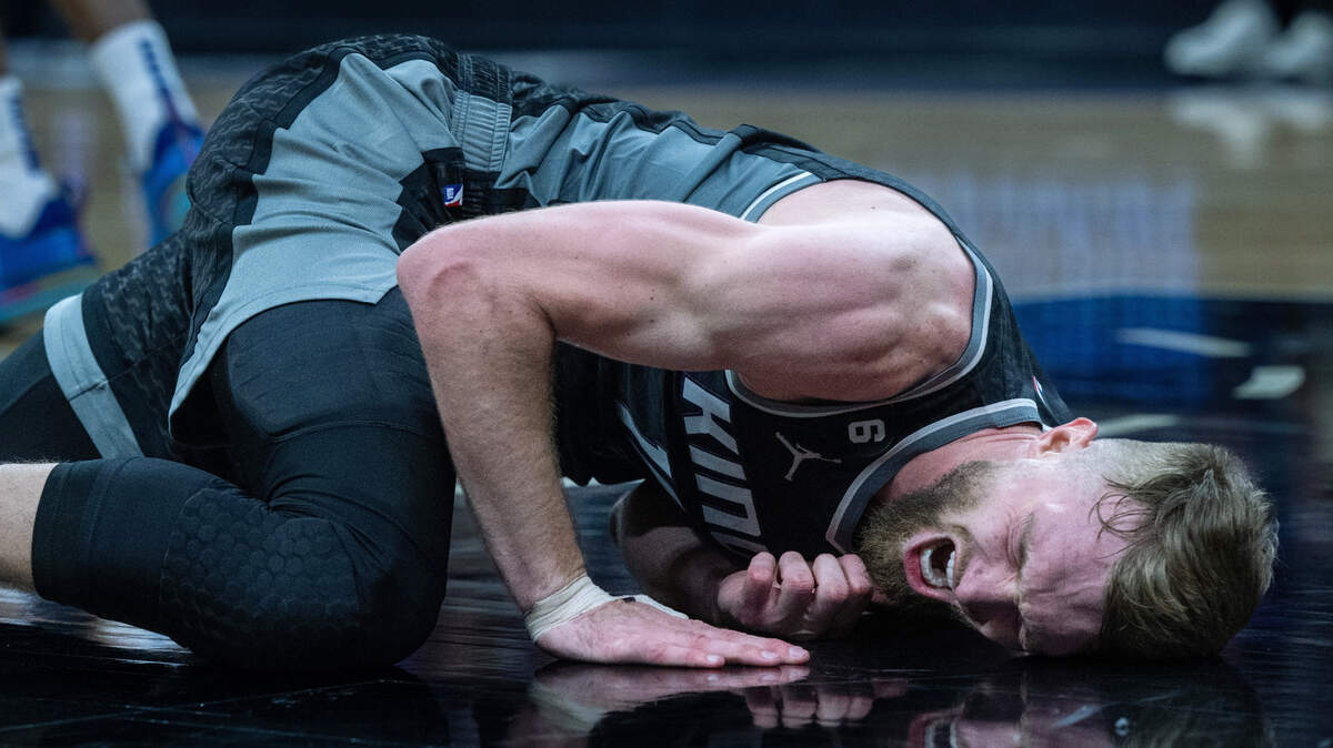 Sacramento Kings center Domantas Sabonis (10) lies on the floor in pain after he was stepped on by Golden State Warriors forward Draymond Green (23) during Game 2 of the first-round NBA playoff series at Golden 1 Center on Monday, April 17, 2023.
