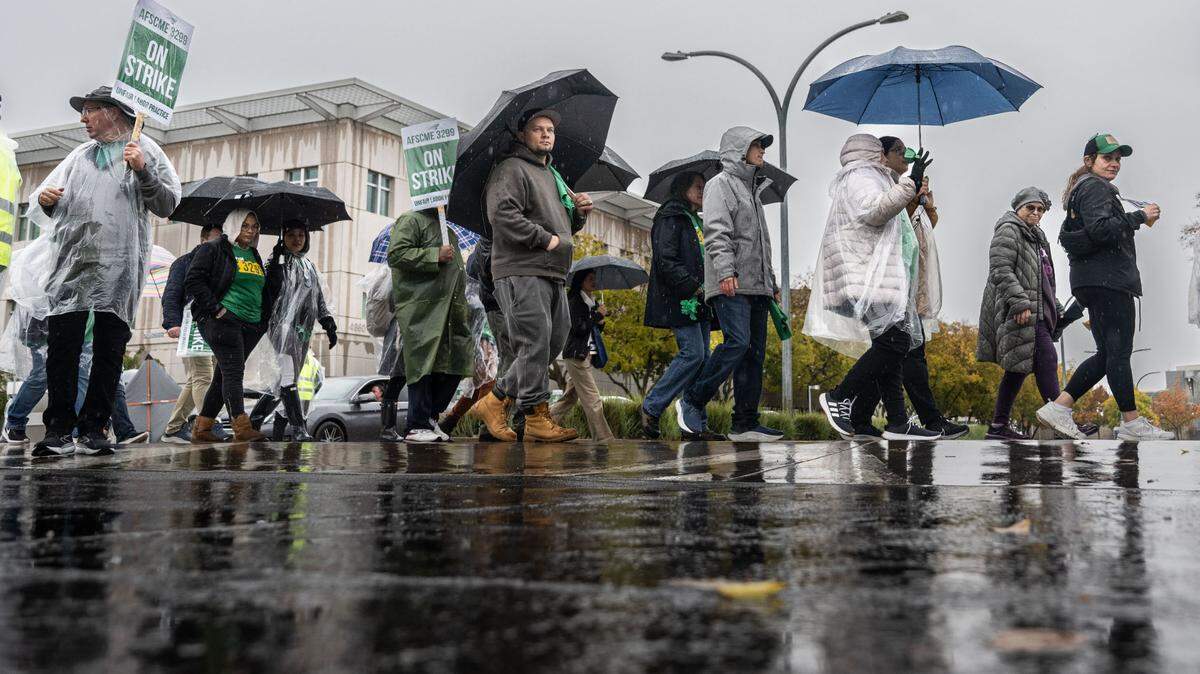 UC Davis Medical Center workers and supporters march on Wednesday, Nov. 20, 2024, in the rain at the Sacramento campus during a statewide strike by AFSCME Local 3299. The workers are asking for higher salaries and a stop to an increase to their medical insurance.