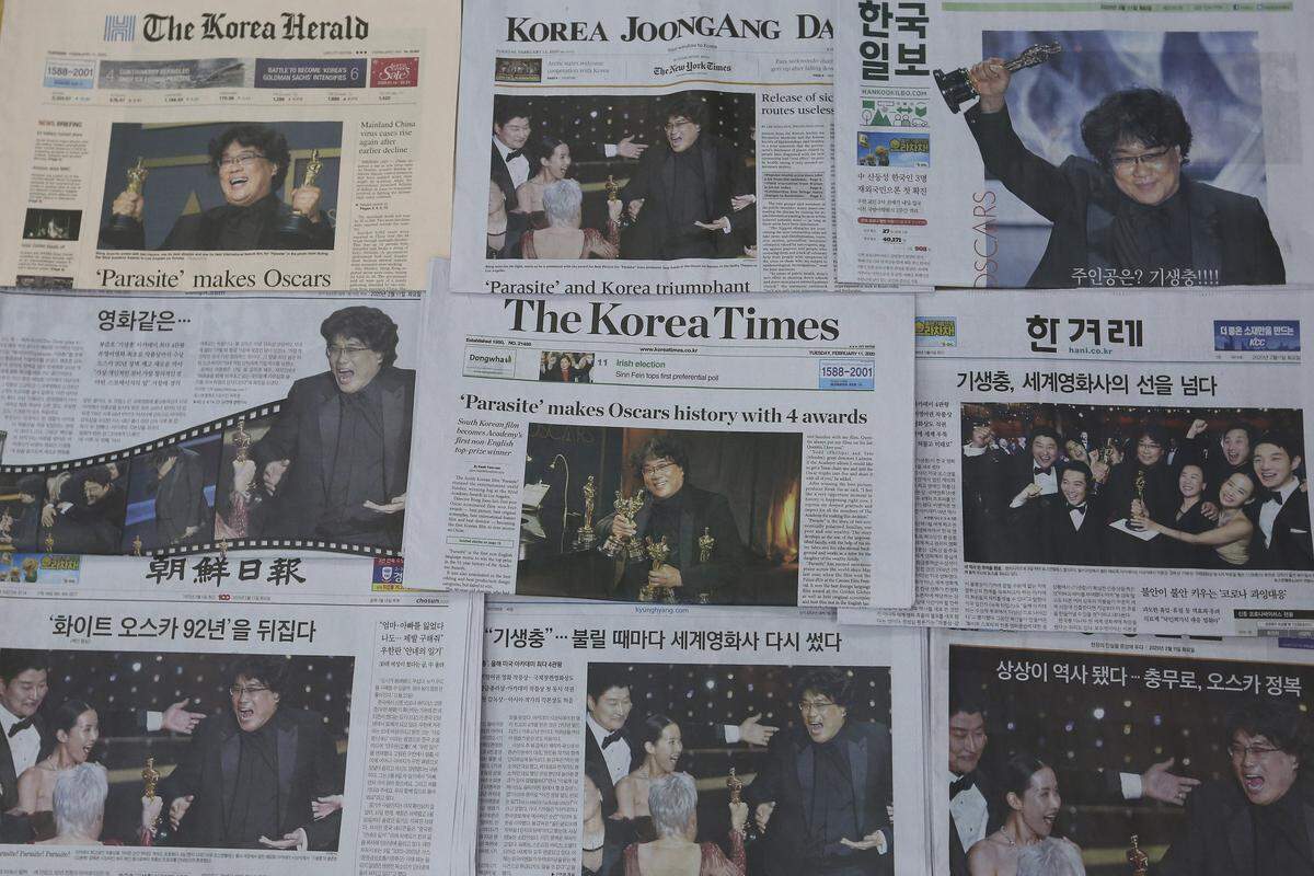 South Korean newspapers carry front-page stories that South Korean director Bong Joon-ho’s “Parasite” makes Oscars, in Seoul, South Korea, Tuesday, Feb. 11, 2020. South Koreans are reveling in writer-director Bong’s dark comic thriller, “Parasite,” which won this year’s Academy Awards for best film and best international feature. The movie itself, however, doesn’t put the country in a particularly positive light. (AP Photo/Ahn Young-joon)