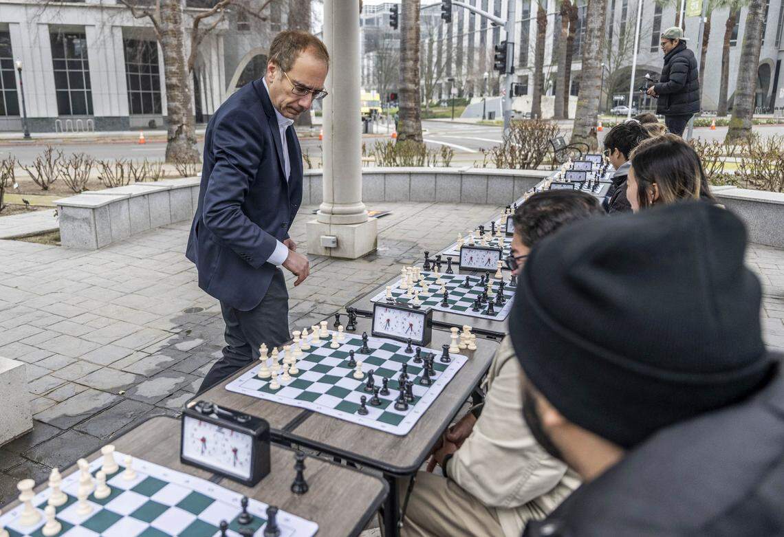 Patrick Wolff, a candidate for California Insurance Commissioner, plays chess with community members at Capitol Park on Tuesday, Jan. 20, 2026. Wolff has been traveling the state challenging the public to beat him — he will pay their home insurance for one month if they win.