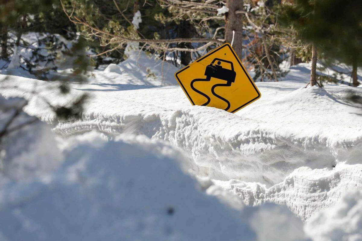 A road sign peeks out from Highway 50 near Phillips Station in El Dorado County on Friday as state water managers measured the snowpack. At nearby Sierra-at-Tahoe resort, the snow total for the winter have reached nearly 500 inches (41 feet).