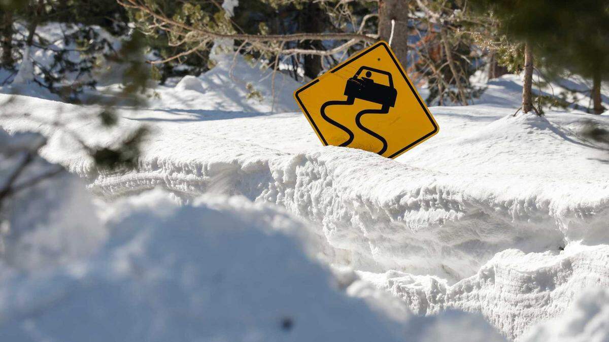 A road sign peeks out from Highway 50 near Phillips Station in El Dorado County on Friday as state water managers measured the snowpack. At nearby Sierra-at-Tahoe resort, the snow total for the winter have reached nearly 500 inches (41 feet).