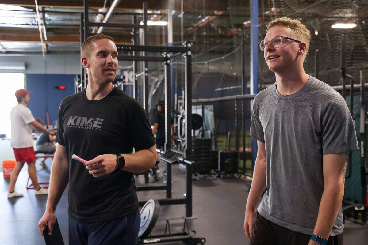 Physical therapist Evan Hauger talks with rehabilitating pitcher Stone Churby after finishing a session at Kime Performance Physical Therapy in Sacramento on June 30, 2021.