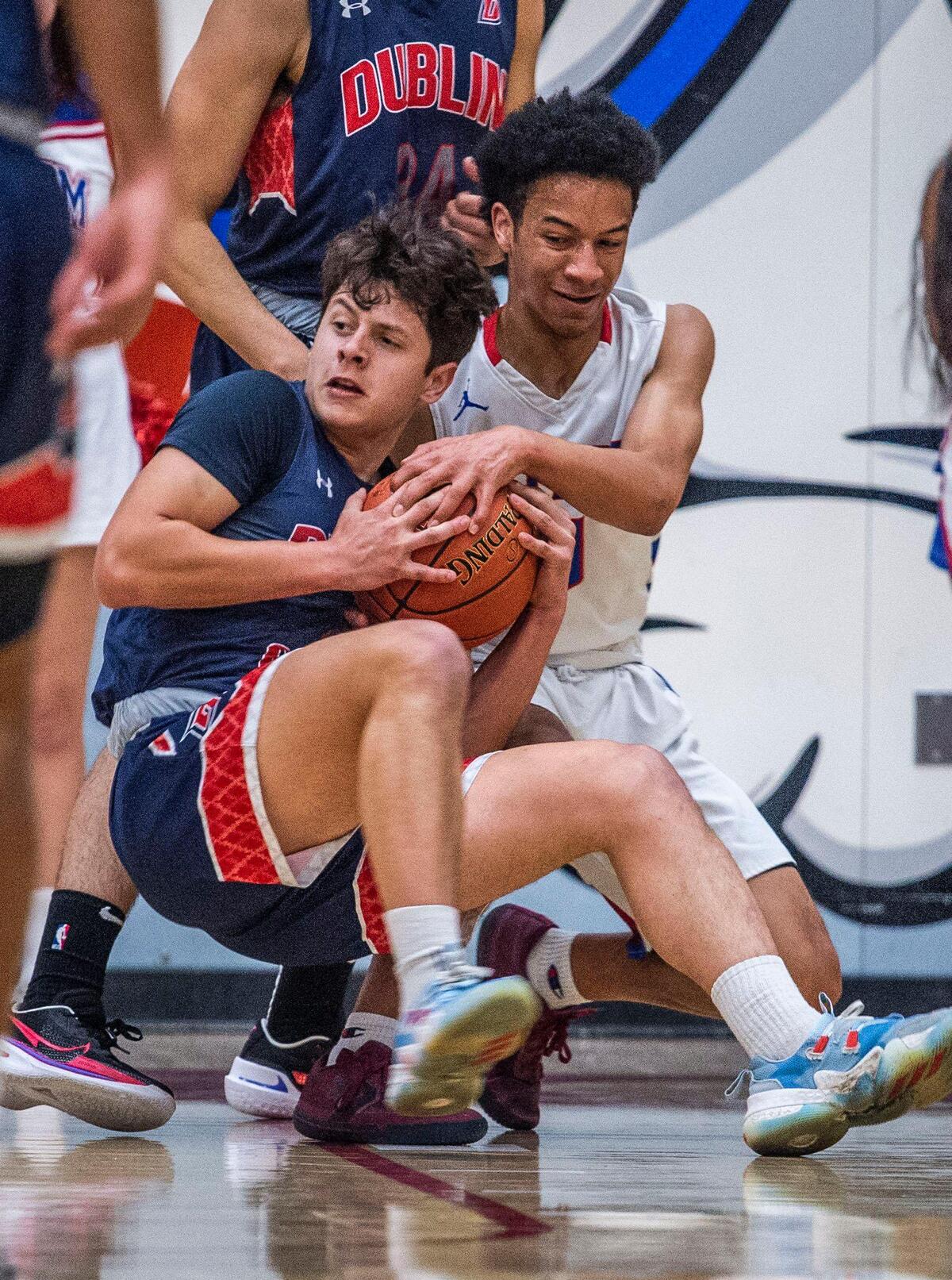 Dublin High School guard Adam Moore (2) fights for the ball with Folsom High School guard Joaquin Battle (10) on Tuesday, March 1, 2022 in Folsom.