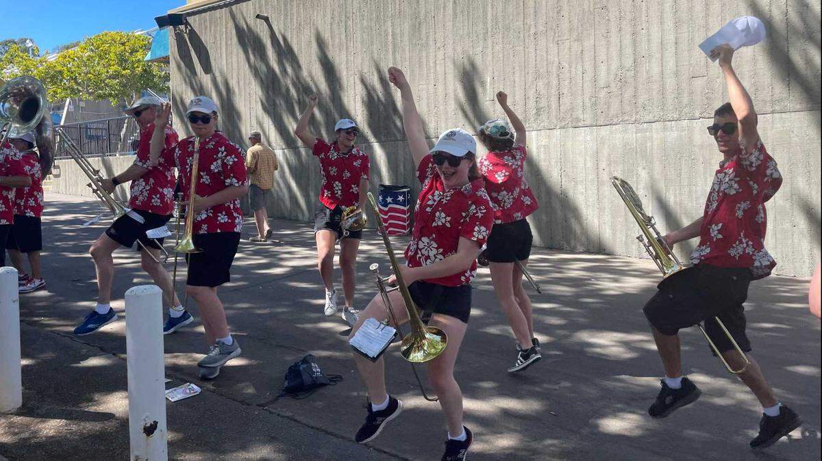 Adam Strauss and other trombone players in the California Repercussions ride their instruments like horses at the California State Fair on Saturday, July 16, 2022.