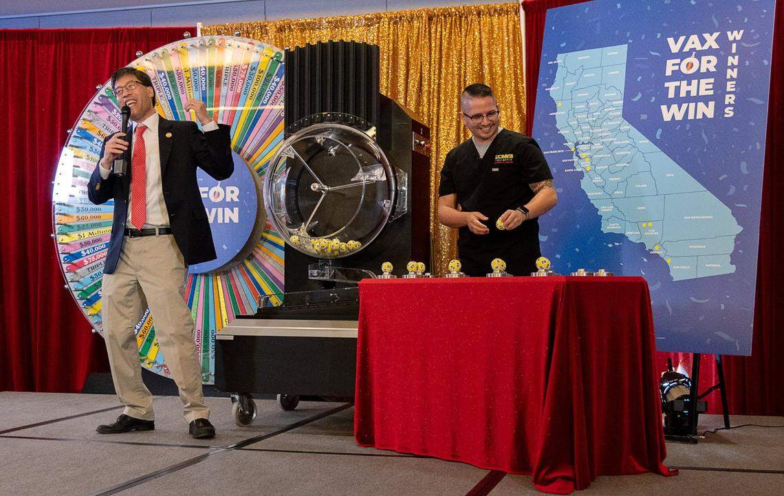 State Sen. Richard Pan, left, holds up a winning lottery ball for the first 15 Californians to be awarded $50,000 for getting vaccinated against COVID-19 at the California Lottery Headquarters in 2021.