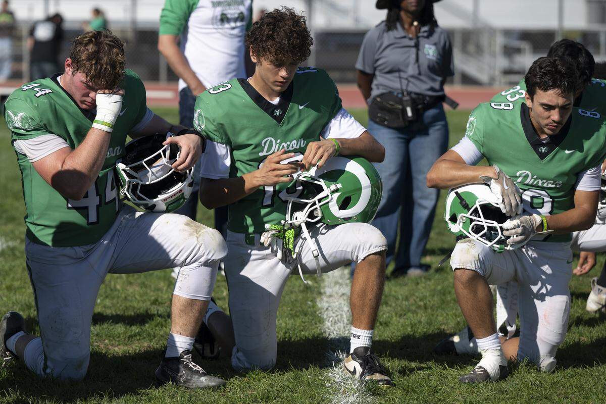 Dixon football players Max Graef, left, and Thomas Sanchez, center, react as they listen to their coaches speak after a varsity football game against Casa Roble in Dixon on Saturday.