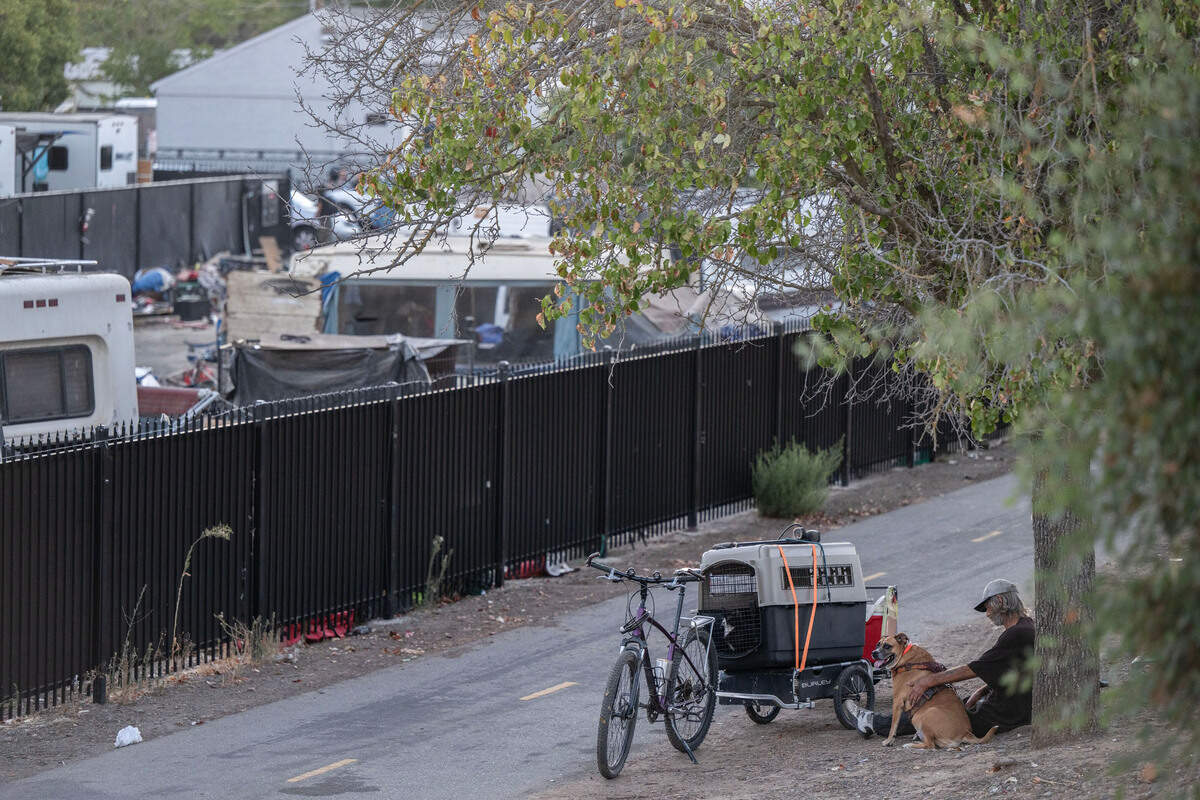 Camp Resolution resident Steven Goble sits with the dog of fellow resident Shonn Adams outside the homeless encampment on Monday, Aug. 26, 2024, before the city came to remove it. Adams, who depends on a generator for her oxygen, had been rescued from the camp by the Sacramento Homeless Union. Goble said he wasn’t sure where he was going, but he was happy to save her dog.