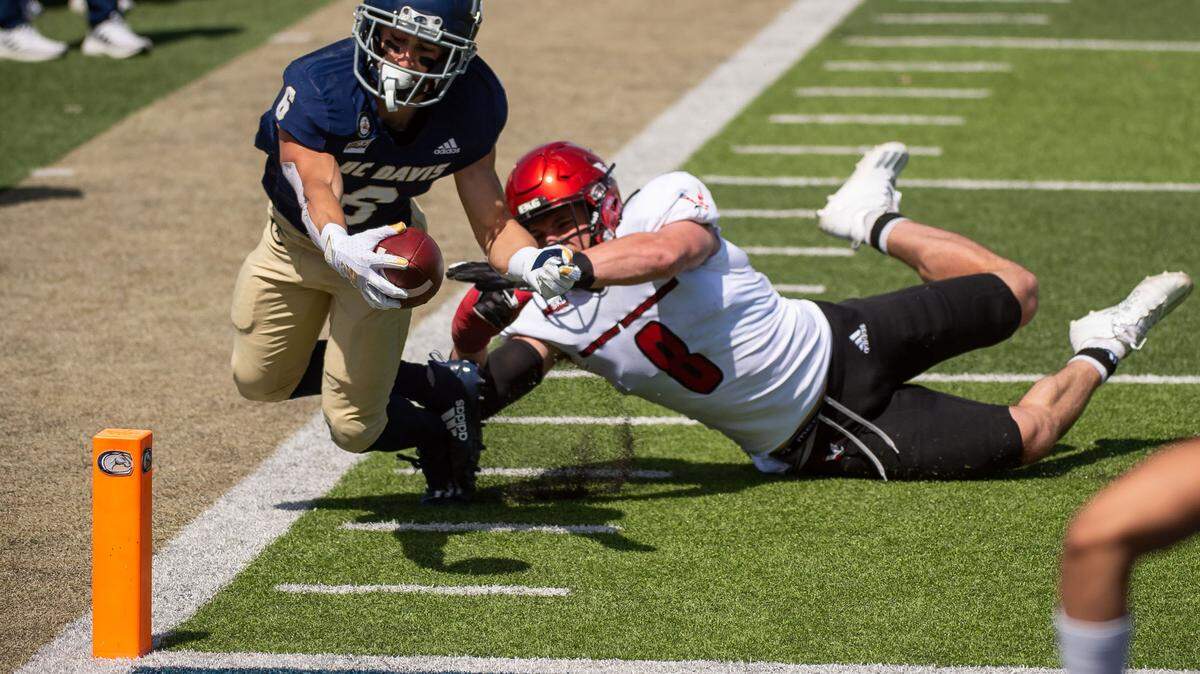 UC Davis Aggies wide receiver Carson Crawford (6) brings the ball to the one yard line, just short of a touchdown, as Eastern Washington Eagles linebacker Jack Sendelbach (8) brings him down during the first quarter of the college football game Saturday, April 3, 2021, at UC Davis Health Stadium. The Aggies were not able to score in the first half.