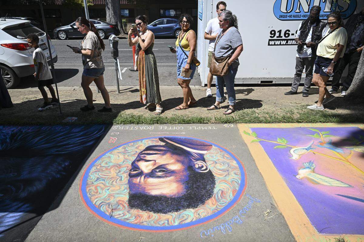 Festival attendees look at completed chalk drawings during Chalk It Up art festival at Fremont Park in Sacramento on Sunday.