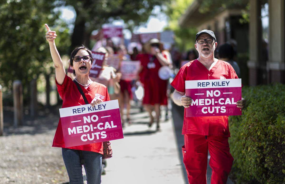 Registered nurses Hope Wallen and John Bergmann rally against the cuts to Medicaid, known as Medi-Cal in California, in July 2025. The cuts were part of legislation in Congress known as President Trump's Big Beautiful Bill.