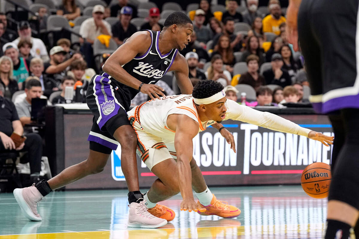 Sacramento Kings guard De’Aaron Fox (5) and and San Antonio Spurs forward Keldon Johnson (3) battle for the loose ball during the first half Friday, Nov. 17, 2023, at Frost Bank Center in San Antonio, Texas.