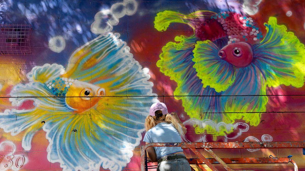 Artist Kosono Okina of Sacramento paints a mural in 2021 at 1730 12th Street in Sacramento during the Wide Open Walls festival. Sacramentans can help douse the city with more murals on these four days in May and June.
