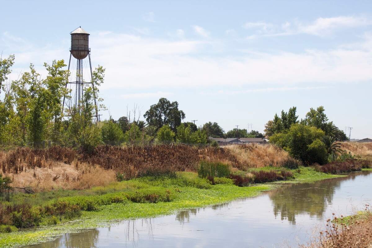 A waterway passes beneath roads leading from Highway 113 into Robbins, a Sutter County farm town. Residents have been without safe drinking water for decades, which a new water well and treatment facility aims to fix.
