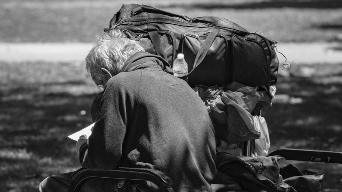 A man enjoys brief respite from the heat on a shaded park bench in Sacramento’s Cesar E. Chavez Plaza in May 2021. It’s a common sight across the Sacramento region; people in need – many with mental health concerns – relying on the solitude of a vacant public space.
