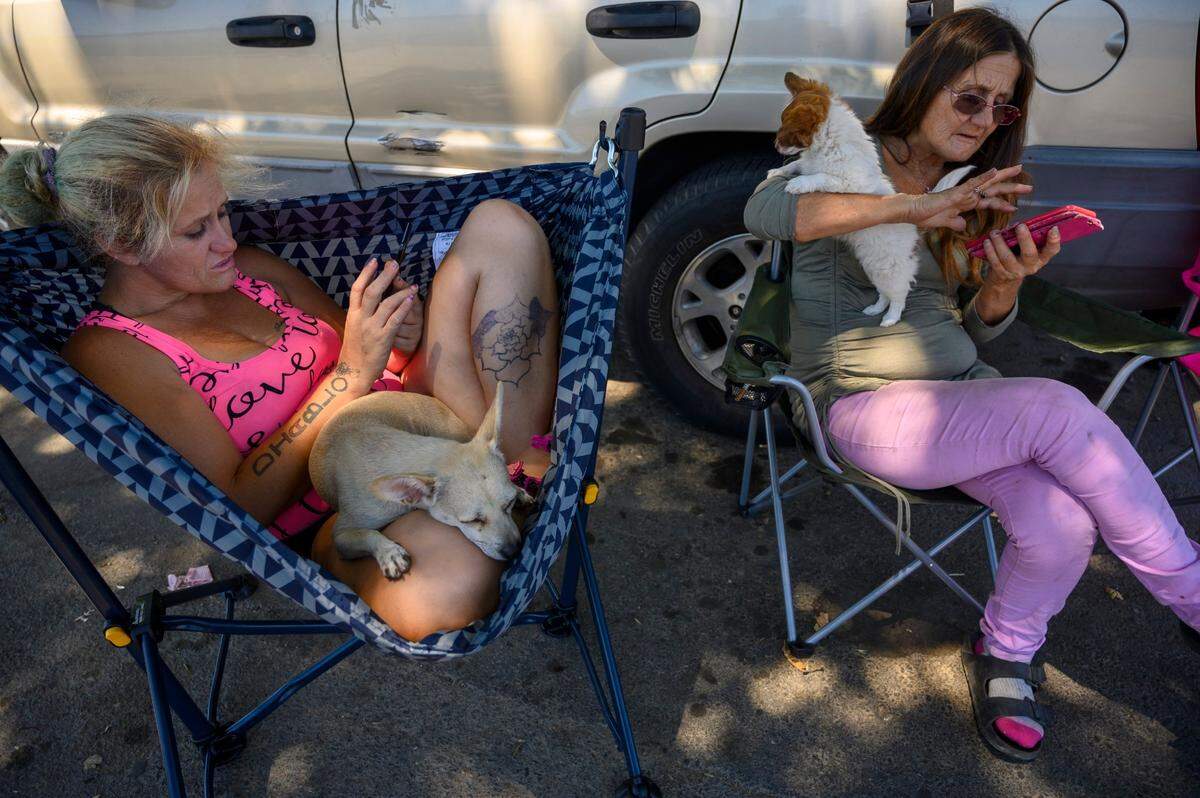 Gwen Mayse, right, and her daughter, Laurane Ivey, search for apartments on their phones in 2019. Mayse had saved $10,000 in Social Security checks but her low credit score and an eviction, made it difficult for her to find housing.