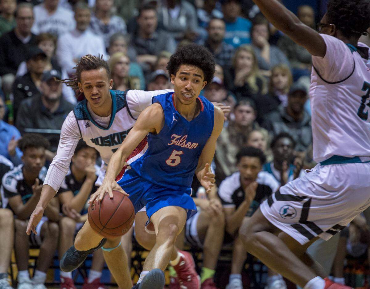 Folsom Bulldogs Jayce McCain (5) dribbles between Sheldon Huskies guard Dale Currie (0) and forward Ronald Agebsar (24) in the first quarter as Sheldon played Folsom in the boys NorCal Open semifinal at Cosumnes River College on Tuesday, March 13, 2018.
