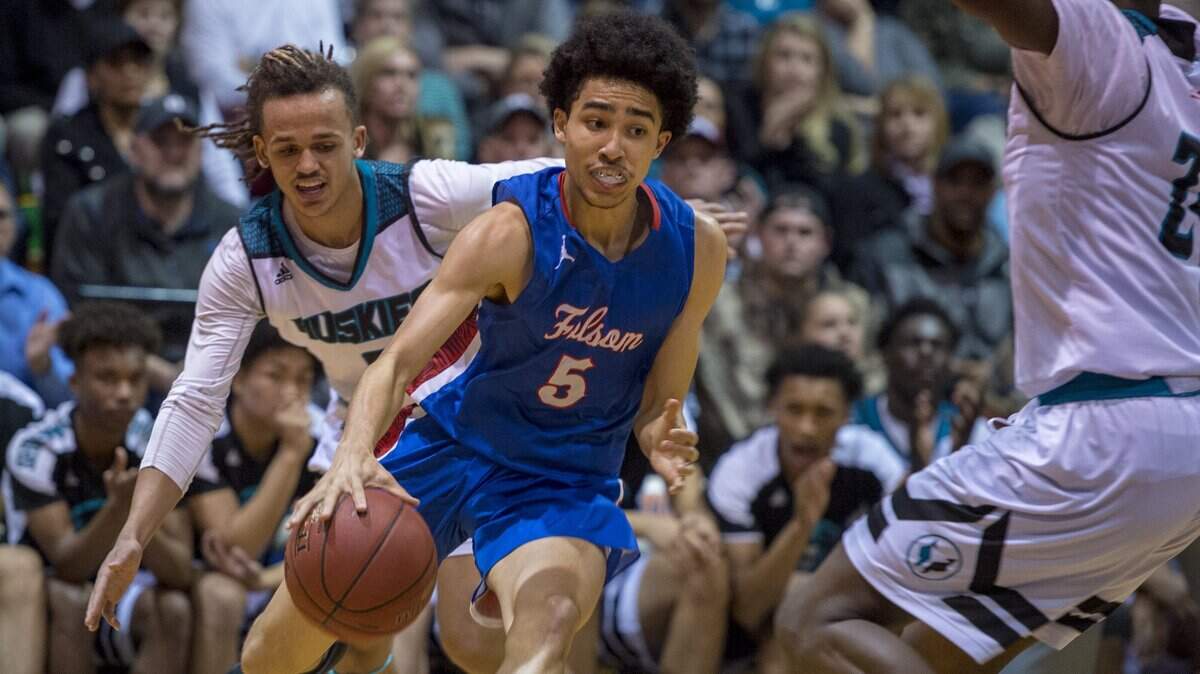 Folsom Bulldogs Jayce McCain (5) dribbles between Sheldon Huskies guard Dale Currie (0) and forward Ronald Agebsar (24) in the first quarter as Sheldon played Folsom in the boys NorCal Open semifinal at Cosumnes River College on Tuesday, March 13, 2018.