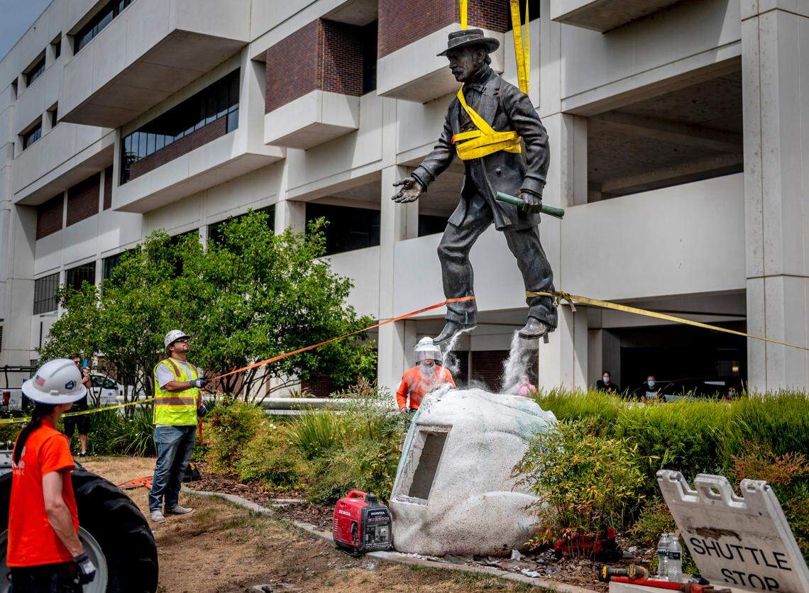 Workers remove a statue of John Sutter, a Swiss settler who built the first European settlement on the site of the city of Sacramento, outside Sutter hospital in midtown on Monday, June 15, 2020. Some historical accounts describe Sutter as using Native Americans as slaves and raping Native American girls as young as age 12.