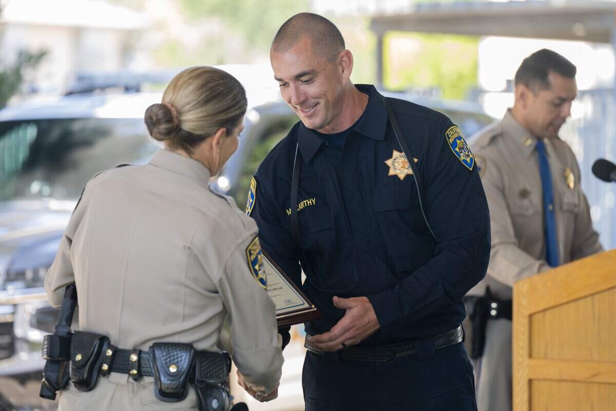 Officer Casey McCarthy receives a graduation plaque for his trained canine, Vader, during the CHP Academy K-9 graduation in West Sacramento on Friday.