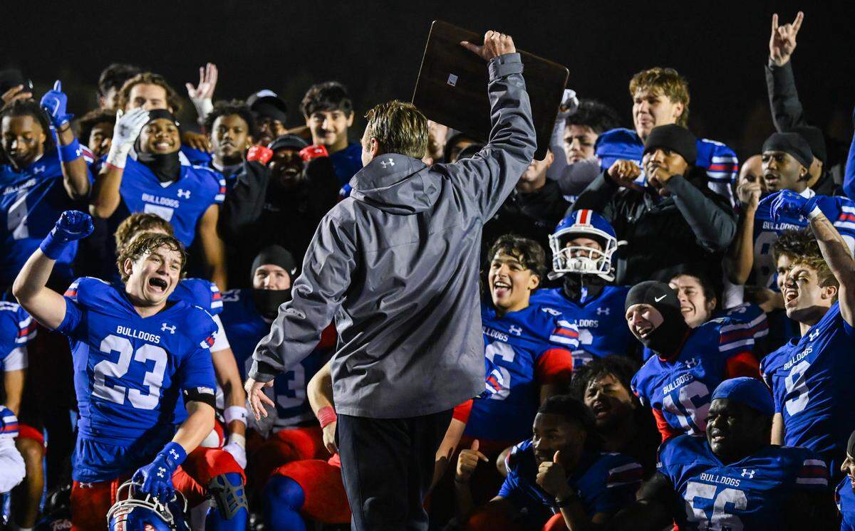 Folsom Bulldogs coach Paul Doherty presents the championship plaque to his team after they defeated the Riordan Crusaders 42-38 In the CIF Northern California Regional Division 1-AA football championship game in Folsom on Friday, Dec. 5, 2025.