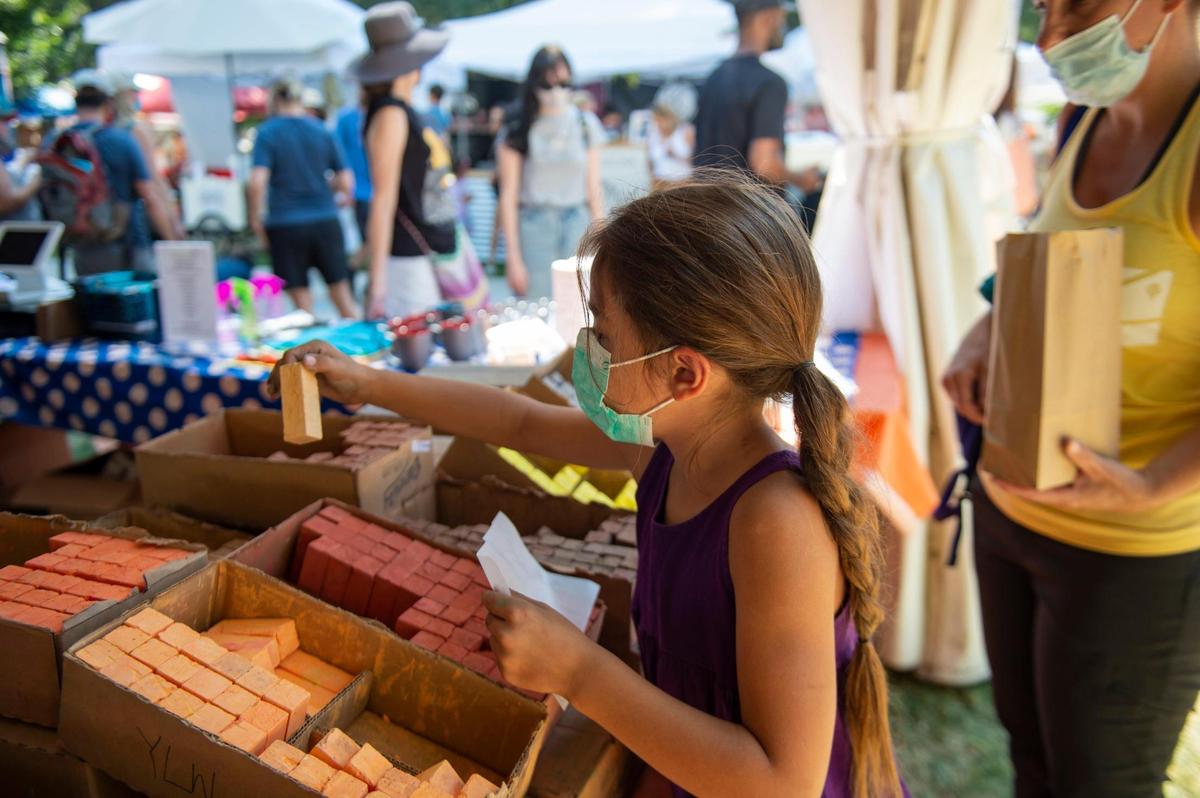 Evelyn Lacoste, 7, of Fair Oaks, picks out chalk to finish her “Underwater Adventure” piece she is creating with her father during the Chalk It Up festival at Fremont Park in midtown Sacramento in 2021.