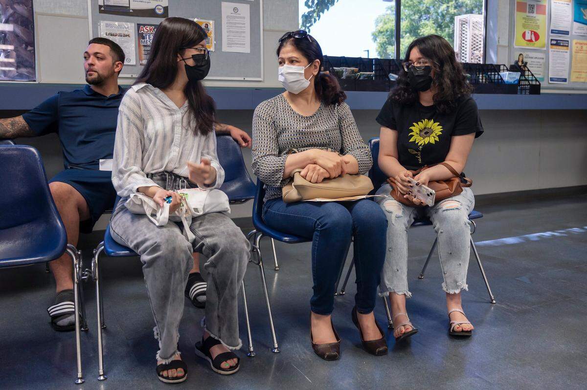 Sadaf Samim, left, 18, waits to take her driver’s permit test with her mother Sajia Ahmad, center, and her sister Sahar Samim, right, 21, at the Broadway DMV in Sacramento on Monday, June 27, 2022.