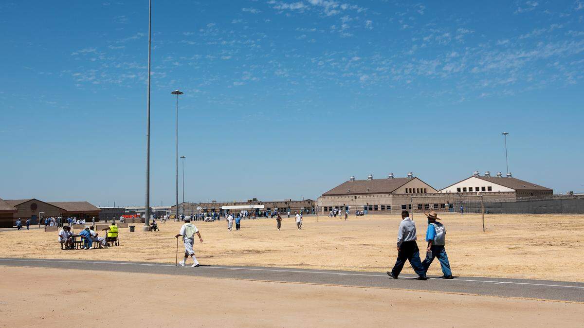 Inmates walk across the grounds of Valley State Prison in Chowchilla, Calif., on Tuesday, July 27, 2021.