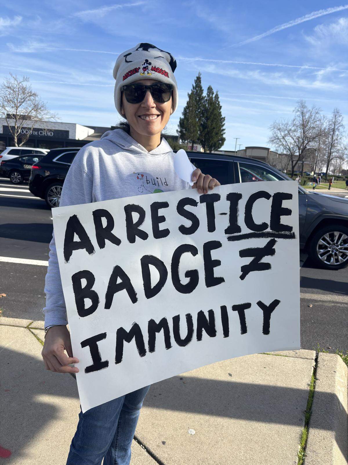 Yuki Rosas, a mother of three school-aged kids, holds a sign reading “Arrest ICE” during a protest outside the Westfield Galleria mall in Roseville on Saturday after a U.S. Immigration and Customs Enforcement agent fatally shot a woman in Minneapolis on Wednesday.