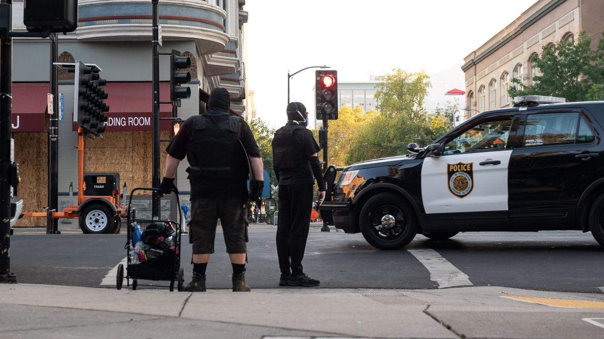 A Sacramento police vehicle passes by protesters on Thursday, Aug. 27, 2020, in downtown Sacramento. Those pictured were attending a protest against police brutality, one of many that took place in summer 2020. In July 2021, a new report found that the Sacramento Police Department uses force disproportional against Black residents.