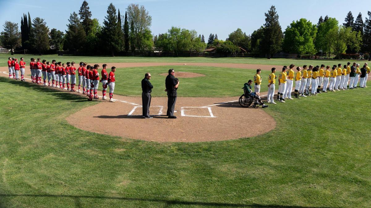 The McClatchy and Kennedy high school baseball teams stand on the baseline during the National Anthem at Kennedy High School in Sacramento, Wednesday, April 6, 2022. This was the first game back in the league since the start of the staffing strike.