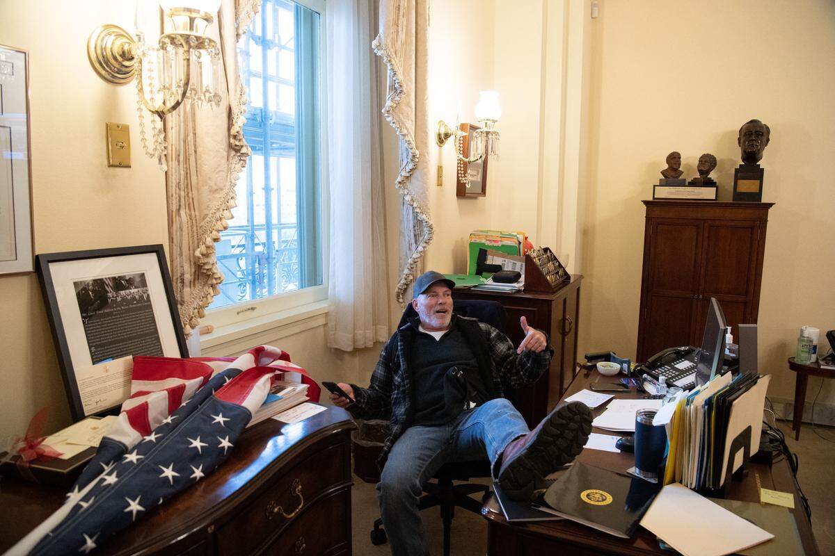 Richard Barnett, a supporter of President Donald Trump, sits inside the office of Speaker of the House Nancy Pelosi as he protests inside the Capitol in Washington, D.C., on Jan. 6, 2021. Demonstrators breeched security and entered the Capitol as Congress debated the a 2020 presidential electoral vote certification.