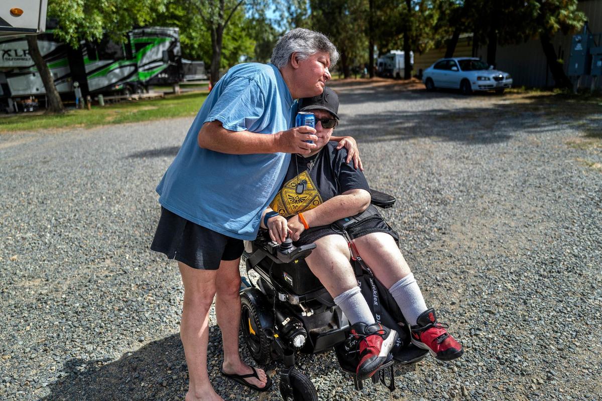 Teri Lindsay hugs daughter Megan Rodman, 34, in Oroville on June 1. Rodman recently had to move into her dad’s home while Lindsay waits on a check from the Fire Victims Trust to remain in a trailer she and her family have lived since their home was lost in the 2018 Camp Fire in Paradise. Rodman suffers from Arthrogryposis, weak muscles, stiff joints and brittle bones.