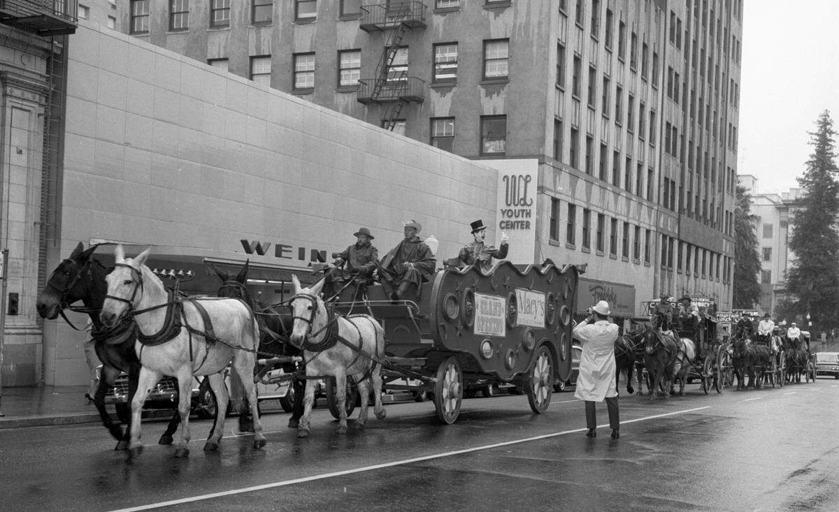 Horse-drawn carriages bearing dignitaries en route from the state Capitol to the Macy’s grand opening in downtown Sacramento on Nov. 4, 1963, parade past the Weinstock's department store. The vintage transportation was in honor of Macy’s founder, who ran a dry-goods store in Marysville during the Gold Rush.