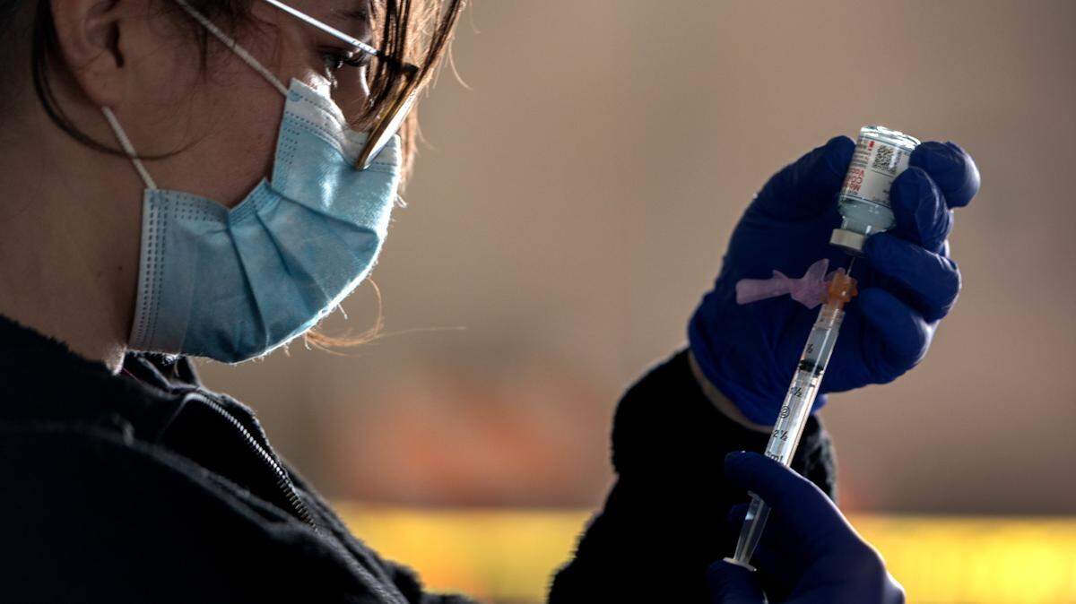 Jenny Ravailov, a medic with the California National Guard, prepares a COVID-19 Moderna vaccine at a drive-thru Sacramento County Public Health clinic at Cal Expo on Thursday, Jan. 21, 2021.
