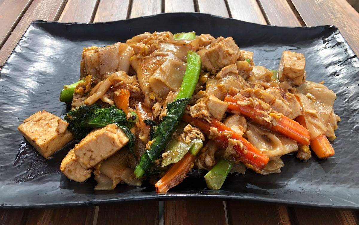 Pad See Eiw from The House of Authentic Ingredients is made with your choice of protein stir-fried with wide rice noodles, Chinese broccoli, carrots and egg.