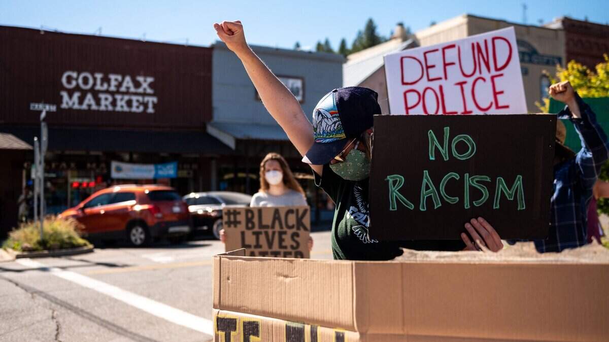 A Placer County resident who did not want to be identified watches her children as she joins demonstrators to rally against racial injustice on Wednesday, June 10, 2020, during the second protest in as many weeks in Colfax. Passing traffic appeared largely supportive, with only a few people shouting for protesters to go home, get jobs or accusing some of being paid to attend.