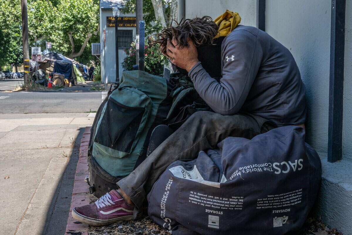 Homeless camper Chadwick Justin Foy, 41, right, says he has no idea where he will move while resting in the shade at the intersection of 28th and C streets on Tuesday, July 18, 2023. The city has given notices to dozens of people living in tents on the sidewalks in that area, near Leland Stanford Park, telling them to move by Wednesday. The notices cite violation of city codes regarding sidewalk obstruction and storage of personal property on public property.