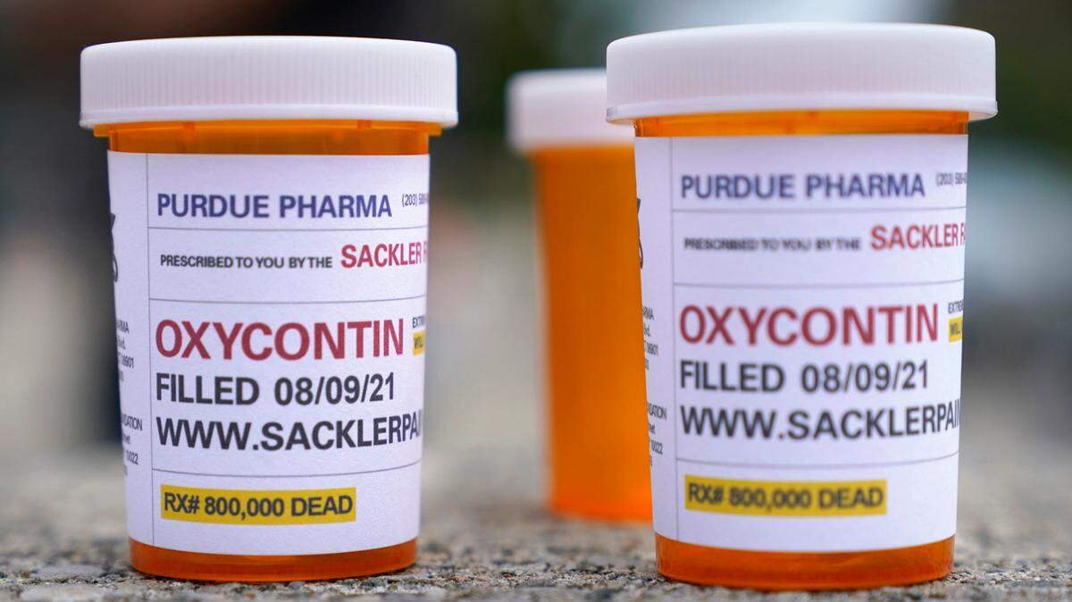 FILE - Fake pill bottles with messages about OxyContin maker Purdue Pharma are displayed during a protest outside the courthouse where the bankruptcy of the company is took place in White Plains, N.Y. on Aug. 9, 2021. (AP Photo/Seth Wenig, File)
