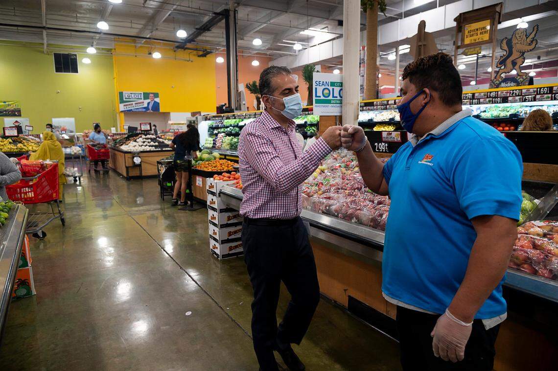 Sean Loloee, entonces candidato al Concejo Municipal de Sacramento, choca el puño con un empleado en su Viva Supermarket en el barrio de Del Paso Heights de Sacramento, en 2020.